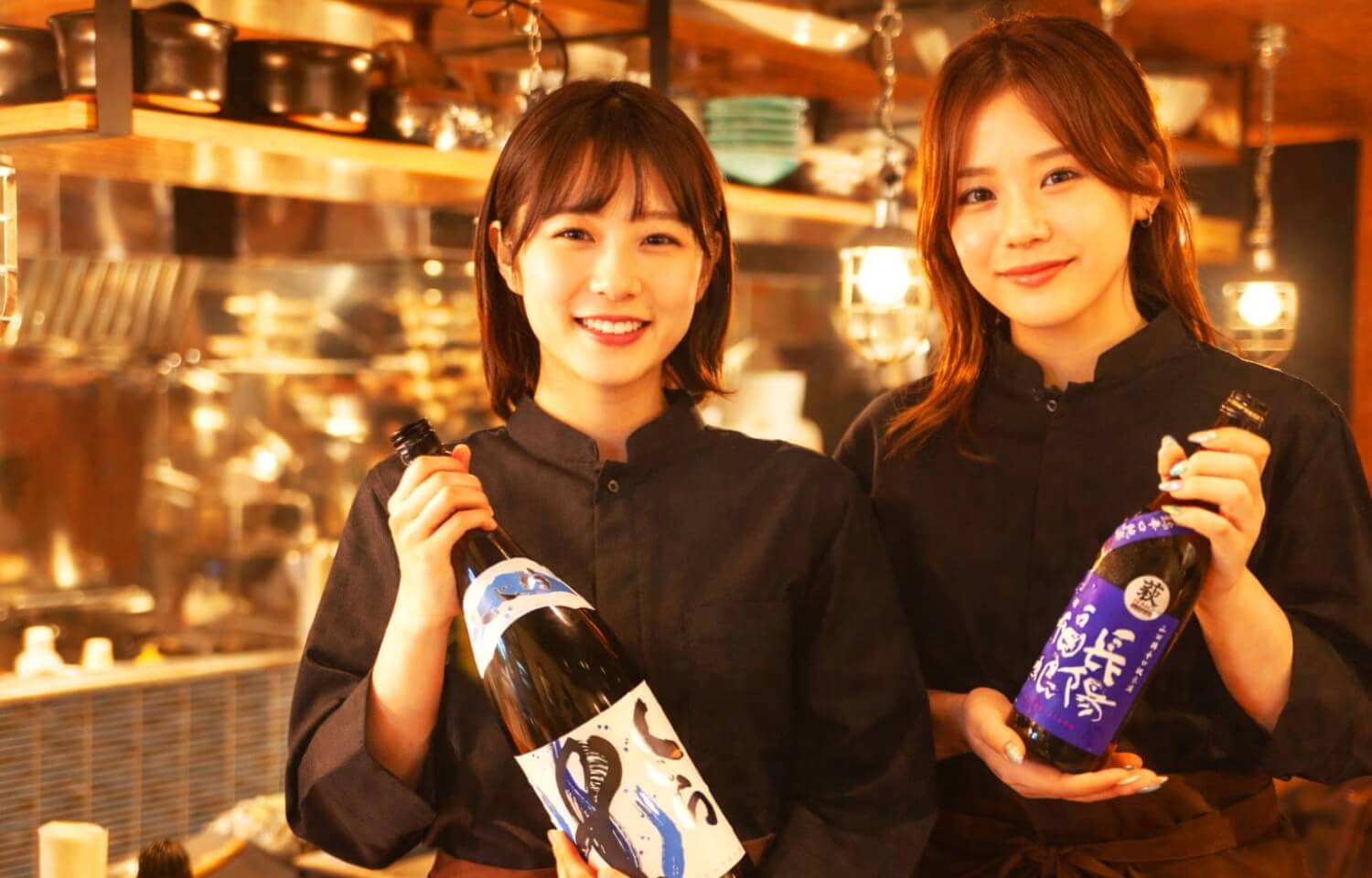 スタッフ2人が酒瓶を持って紹介している写真